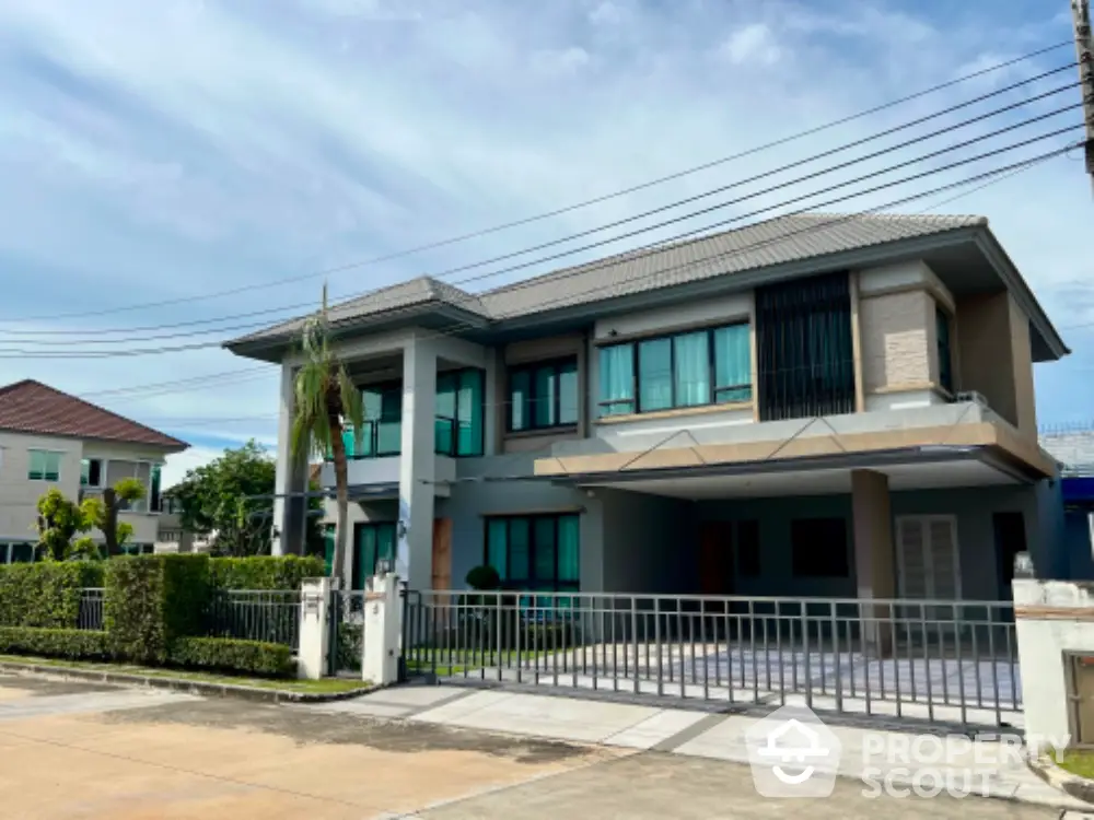 Modern two-story house with spacious driveway and lush greenery in a serene neighborhood.