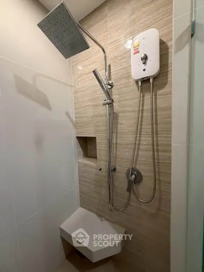 Modern bathroom with sleek shower fixtures and built-in shelf, perfect for contemporary living.
