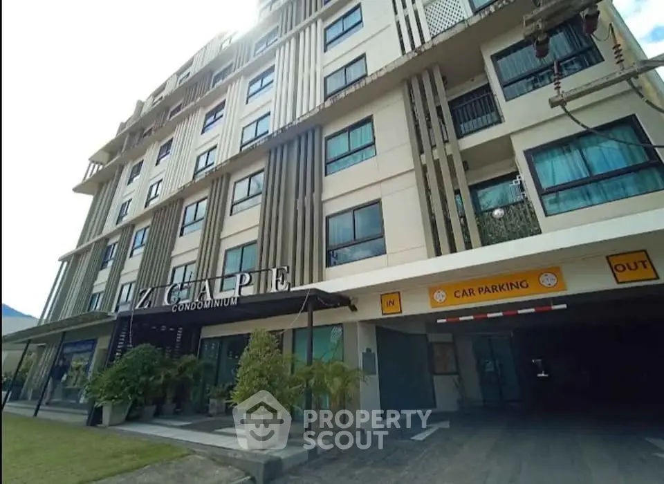Modern condominium building with parking entrance and lush greenery