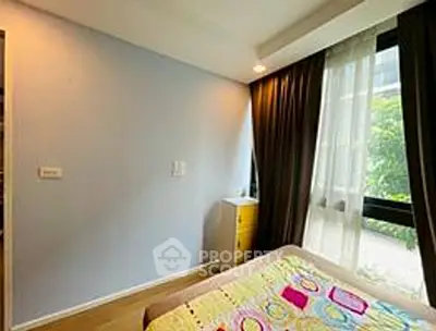 Cozy bedroom with large window and modern decor in a stylish apartment.