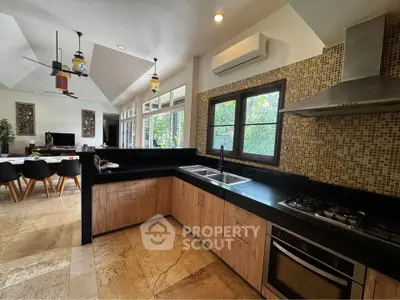 Spacious kitchen with modern appliances and open layout, featuring a gas stove and elegant dining area.