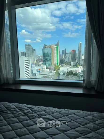 Stunning cityscape view from a high-rise bedroom window with modern skyline.