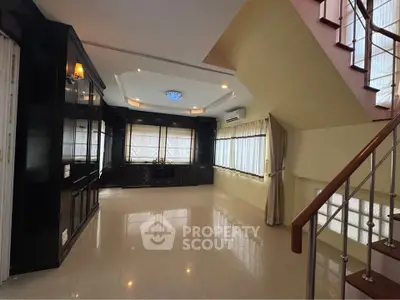 Spacious living room with elegant staircase and large windows