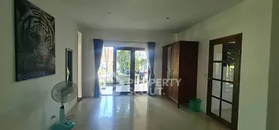 Spacious living room with large windows and garden view, featuring elegant decor and natural light.