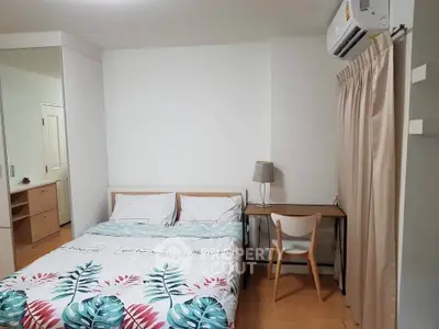 Cozy bedroom with modern decor, featuring a double bed, desk, and air conditioning unit.