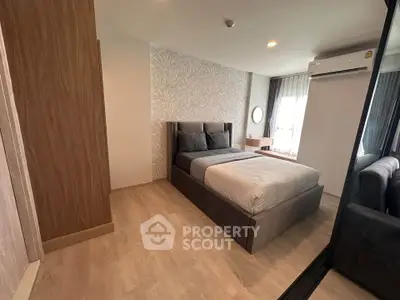 Modern bedroom with stylish decor and natural light in a cozy apartment.