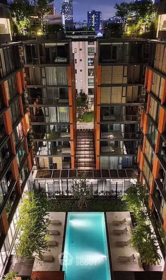 Luxurious urban apartment complex with stunning rooftop pool and city skyline views.