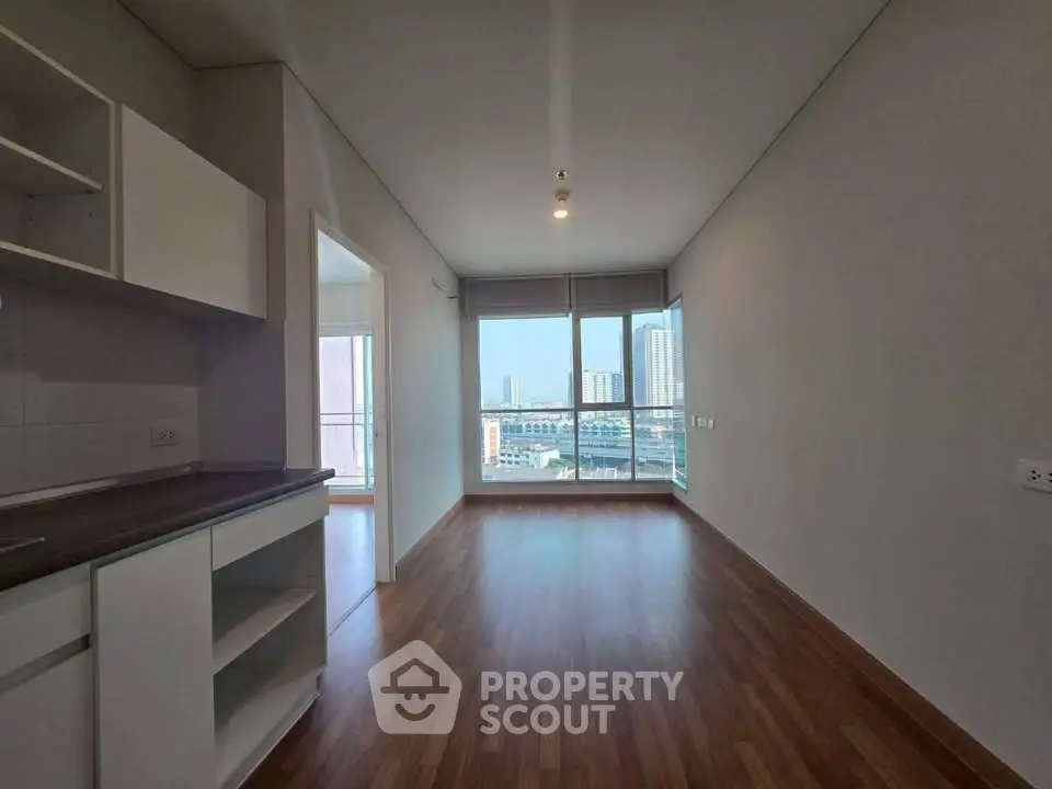 Spacious modern apartment with open layout and stunning city view through large windows.