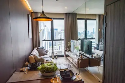 Modern living room with city view, stylish decor, and dining area in a high-rise apartment.