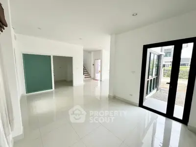 Spacious modern living area with sleek tile flooring and large windows for natural light.