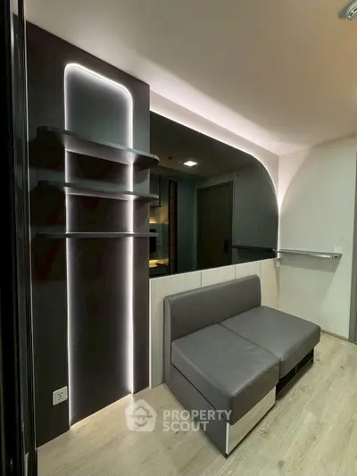 Modern living room with sleek design and ambient lighting, featuring a stylish sofa and contemporary shelving.