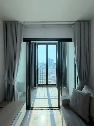 Bright living room with large windows and city view, featuring modern decor and cozy seating.