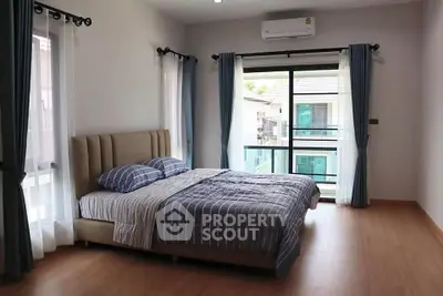 Spacious bedroom with modern decor and large windows for natural light