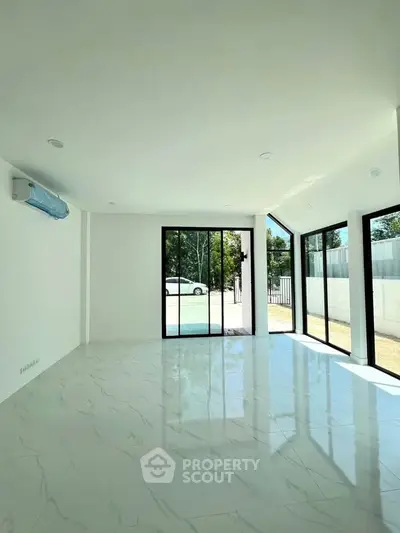 Spacious modern living room with large windows and pool view