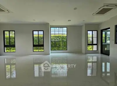 Spacious modern living room with large windows and glossy floors