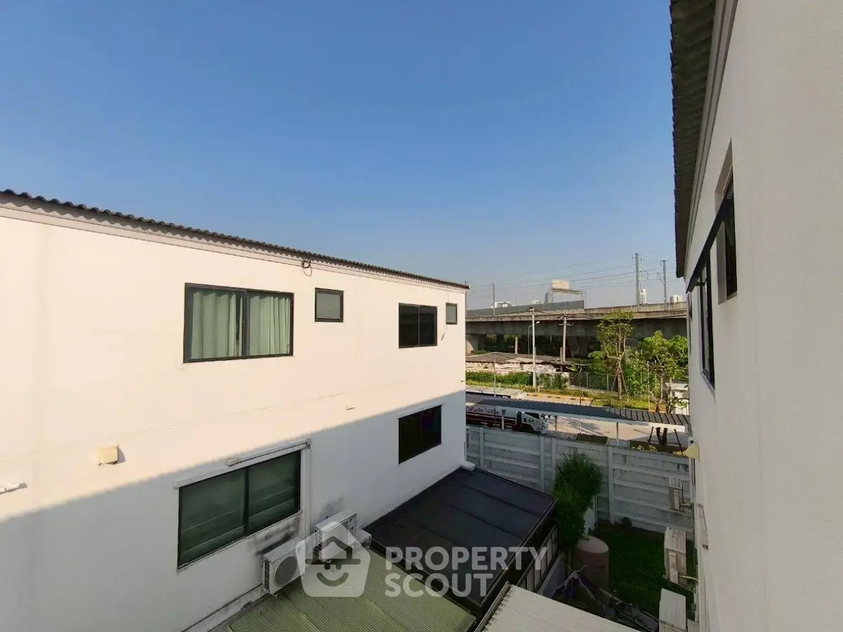 Modern residential building exterior with clear blue sky and urban surroundings.