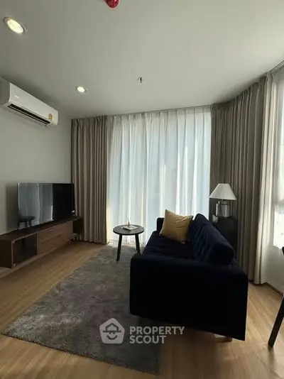 Modern living room with sleek furniture and large windows offering natural light.