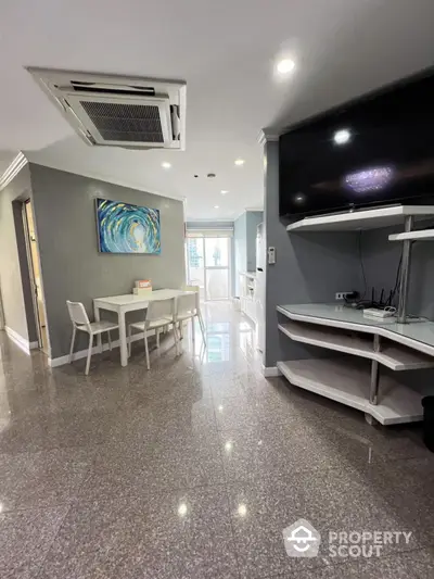 Modern living room with sleek design, featuring a dining area and large TV, perfect for urban living.