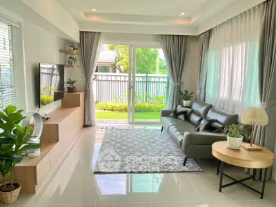 Bright and modern living room with large windows, stylish furniture, and garden view.