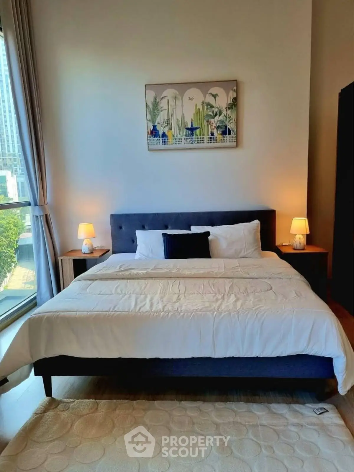 Modern bedroom with large bed and stylish decor in a high-rise apartment.