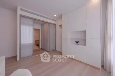 Spacious modern bedroom with built-in storage and sliding wardrobe doors