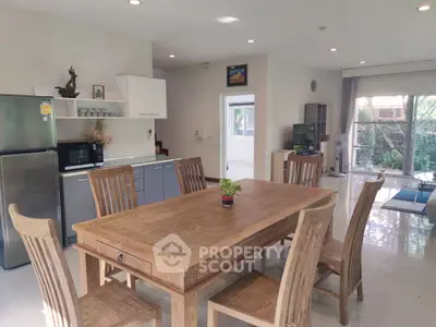 Spacious open-plan kitchen and dining area with wooden furniture and modern appliances.