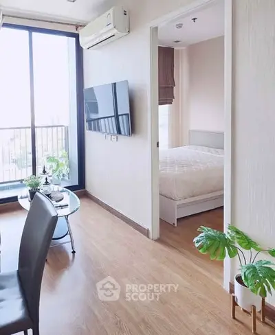 Modern apartment interior with living room and bedroom, featuring large windows and stylish decor.