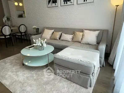 Elegant living room with modern decor, cozy sofa, and stylish round glass coffee table.