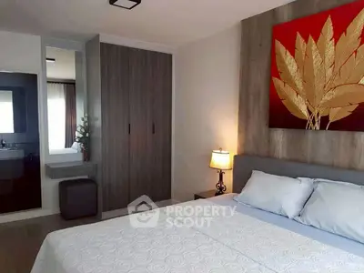 Modern bedroom with stylish decor and cozy ambiance, featuring a large wardrobe and elegant artwork.