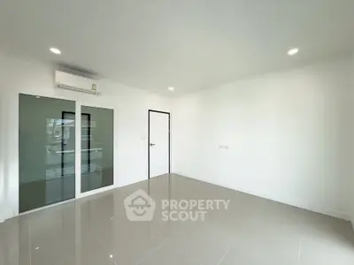 Spacious unfurnished room with glossy tiled floor and sliding glass door, perfect for customization.