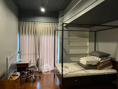 Cozy bedroom with four-poster bed and study desk, ideal for relaxation and productivity.