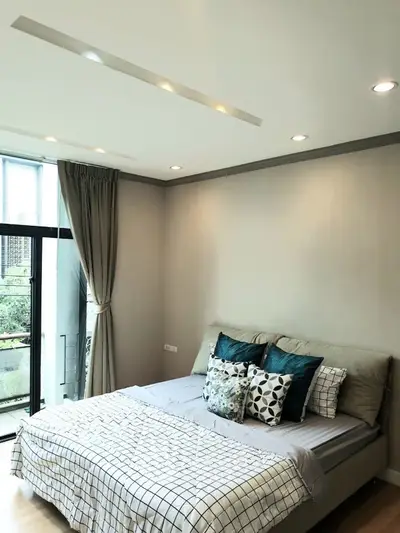 Modern bedroom with elegant decor and large window offering natural light