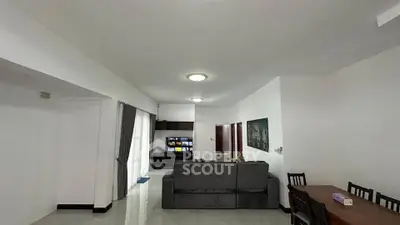 Spacious living room with modern decor and ample natural light, perfect for relaxation and entertainment.