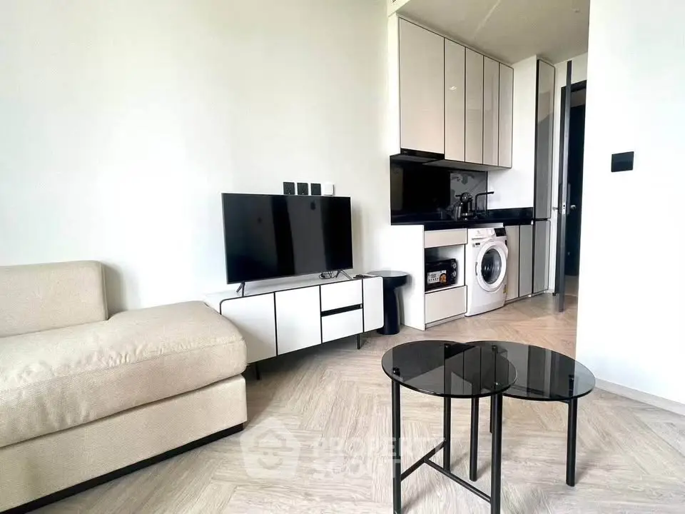 Modern living room with sleek furniture and integrated kitchen appliances in a stylish apartment.
