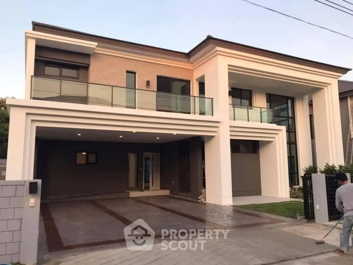 Modern luxury two-story house with spacious driveway and elegant balcony.