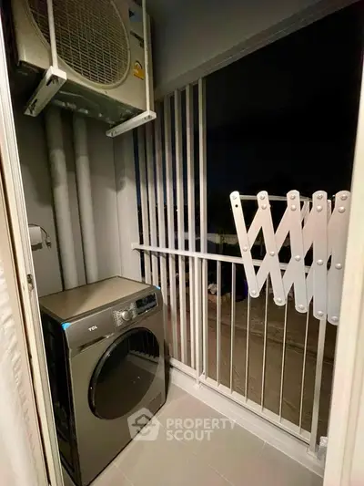 Compact laundry area with modern washing machine and outdoor view