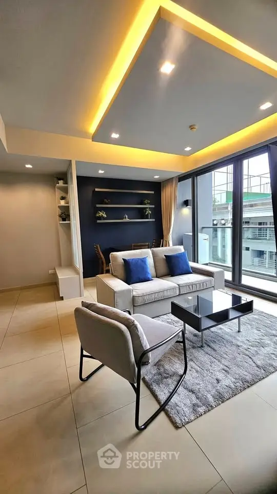 Modern living room with stylish furniture and large windows offering city views.