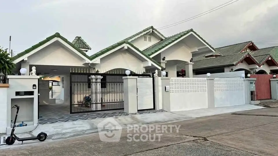 Charming suburban house with green roof and gated entrance, perfect for family living.