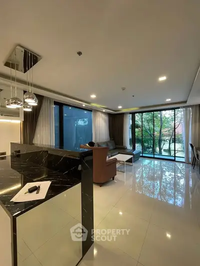 Spacious modern living room with floor-to-ceiling windows and sleek marble accents.