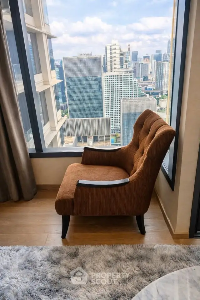 Luxurious high-rise apartment with stunning city view from cozy living room corner.