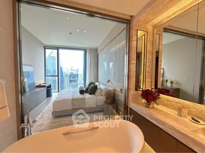 Luxurious bedroom with city view and modern bathroom featuring a sleek bathtub.