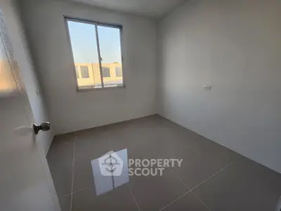 Minimalist empty room with large window and tiled floor, perfect for customization.