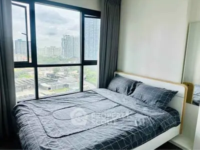 Modern bedroom with large window offering city view, featuring a stylish bed and contemporary decor.