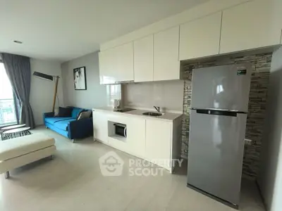 Modern open-layout kitchen with sleek appliances and cozy living area, perfect for urban living.