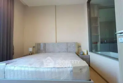 Modern bedroom with large window and minimalist decor, featuring a comfortable bed and neutral tones.