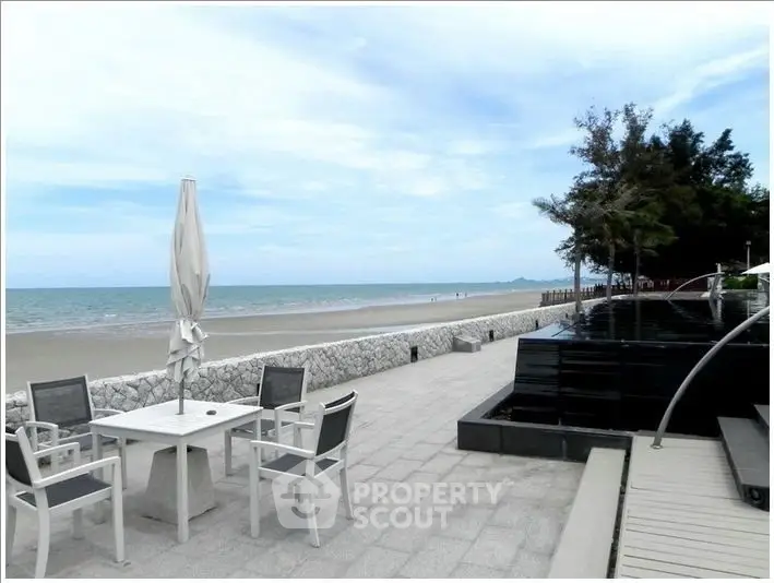 Stunning beachfront patio with ocean view and modern outdoor seating.