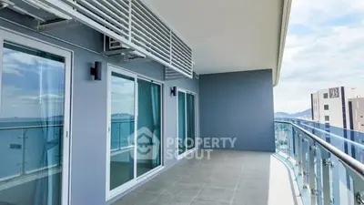Spacious modern balcony with glass railing and city view