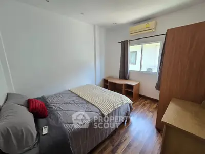Cozy bedroom with wooden flooring and natural light