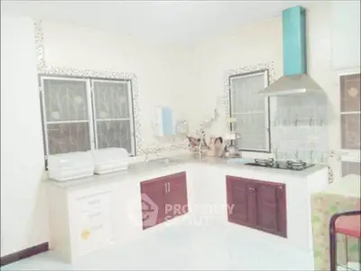 Spacious kitchen with modern gas stove and ample storage in a bright, airy setting.