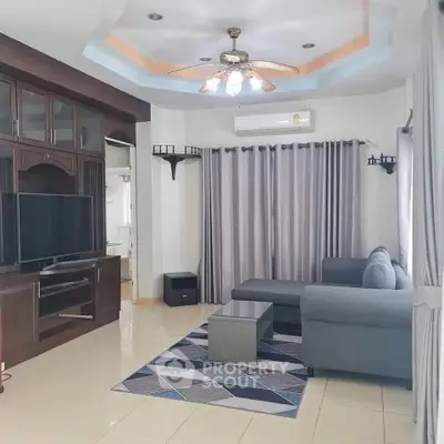 Spacious living room with modern decor and large TV unit, perfect for relaxation.